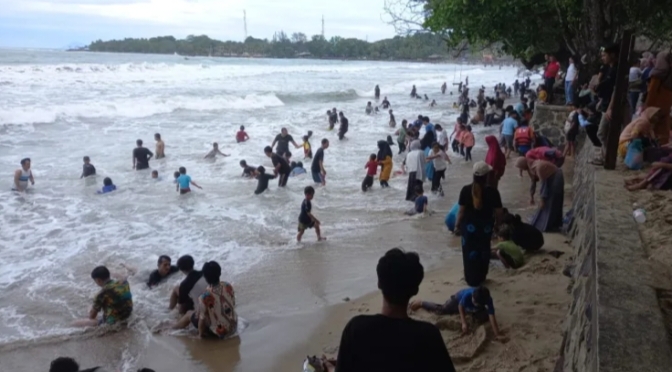 Wisatawan asik bermain air di Pantai Pasir Putih Carita, Pandeglang. (Foto : TLii/Ikhsan)