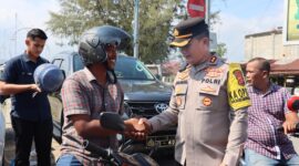 Kapolres Pidie Jaya AKBP Ahmad Faisal Pasaribu, S.H., S.I.K., M.H., membagikan helm gratis kepada pengendara sepeda motor di Simpang Layang Lampu Merah Meureudu, Selasa (11/2) Foto.Ist