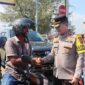 Kapolres Pidie Jaya AKBP Ahmad Faisal Pasaribu, S.H., S.I.K., M.H., membagikan helm gratis kepada pengendara sepeda motor di Simpang Layang Lampu Merah Meureudu, Selasa (11/2) Foto.Ist