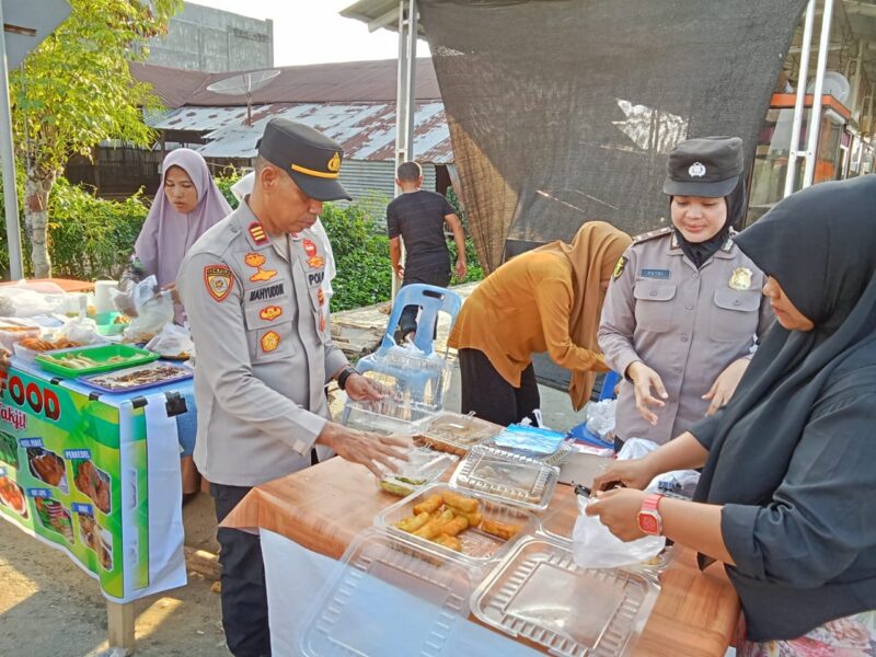 Personel Polres Pidie Jaya Membeli Takjil pada pedagang untuk di bagikan gratis kepada masyarakat yang melintas di Jalan Teuku Syik Pante Geulima, Gampong Beurawang, Kecamatan Meureudu, Selasa (4/3/2025)