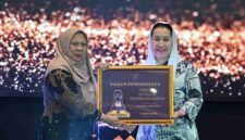 Wakil Gubernur Sulawesi Tengah dr. Reny A. Lamadjido, Sp.PK., M.Kes menyerahkan Paritrana Award kategori pemerintah kabupaten/kota terbaik kepada Wakil Walikota Palu Imelda Liliana Muhidin, S.E., M.A.P.