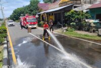 Damkar Tapaktuan Tanggap Cepat Bersihkan Tumpahan Minyak di Depan SMA 2
