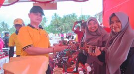Kapolres Pidie Jaya, AKBP Ahmad Faisal Pasaribu, membeli produk yang di pamerkan bazar UMKM HUT Bhayangkara di halaman Mapolres, Sabtu (21/6) Foto Ist.