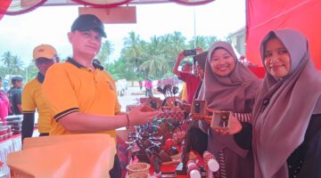 Kapolres Pidie Jaya, AKBP Ahmad Faisal Pasaribu, membeli produk yang di pamerkan bazar UMKM HUT Bhayangkara di halaman Mapolres, Sabtu (21/6) Foto Ist.