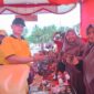 Kapolres Pidie Jaya, AKBP Ahmad Faisal Pasaribu, membeli produk yang di pamerkan bazar UMKM HUT Bhayangkara di halaman Mapolres, Sabtu (21/6) Foto Ist.