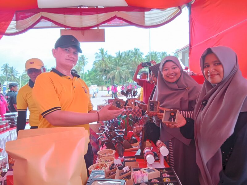Kapolres Pidie Jaya, AKBP Ahmad Faisal Pasaribu, membeli produk yang di pamerkan bazar UMKM HUT Bhayangkara di halaman Mapolres, Sabtu (21/6) Foto Ist.