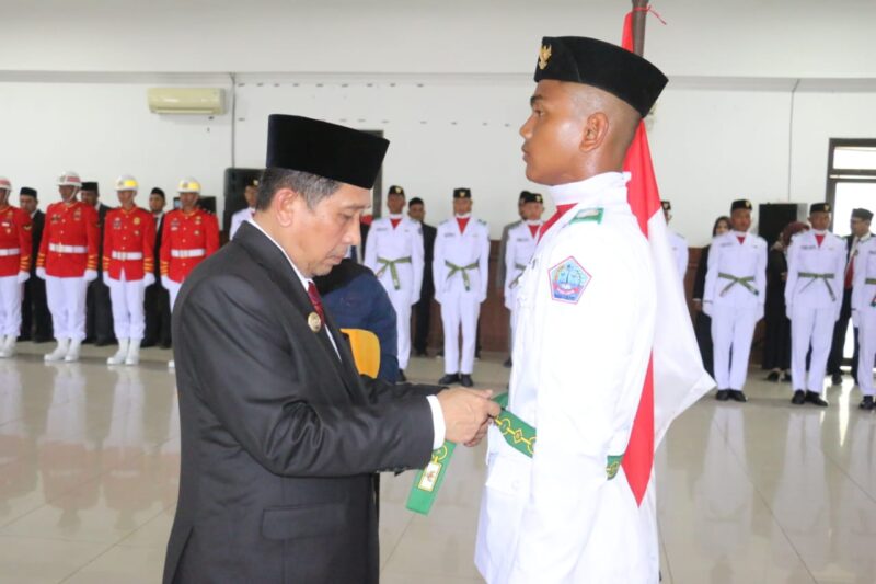 Bupati Pidie Jaya, H. Sibral Malasyi. MA, S.Sos, ME,. Memasang Sabuk pada Perwakilan Pasukan Pengibar Bendera Pusaka (Paskibraka). di Aula Cot Trieng, Kantor Bupati , Rabu (13/8/2025). Foto.Ist.