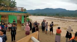 Warga berkumpul dan menyaksikan kondisi pascabanjir bandang di Kecamatan Putri Betung, Gayo Lues, Jumat (28/11/2025). Tampak