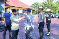 Wakil Bupati Aceh Barat Said Fadheil, SH memasang pita kepada perwakilan Personil saat memimpin Apel Gelar Pasukan Operasi Ketupat 2026 di halaman Polres Aceh Barat, Kamis (12/3/2026), Foto Dok: