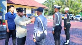 Wakil Bupati Aceh Barat Said Fadheil, SH memasang pita kepada perwakilan Personil saat memimpin Apel Gelar Pasukan Operasi Ketupat 2026 di halaman Polres Aceh Barat, Kamis (12/3/2026), Foto Dok: